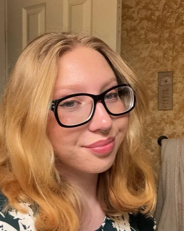 M Darlin', smiling, in glasses